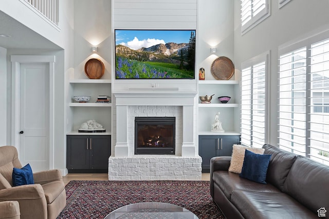 living room featuring a high ceiling, built in shelves, and a wealth of natural light