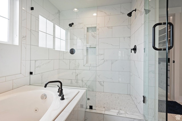 bathroom with a jetted tub and a stall shower