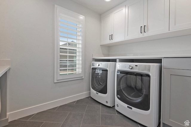 laundry room with cabinet space, baseboards, dark tile patterned flooring, and separate washer and dryer