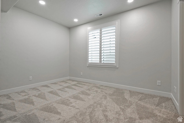 spare room with recessed lighting, visible vents, baseboards, and light carpet