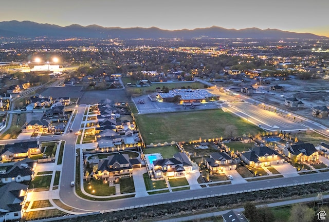aerial view at dusk featuring a residential view and a mountain view