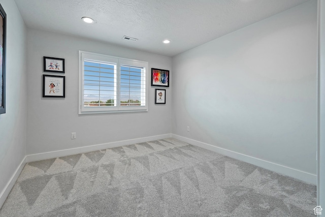 empty room featuring recessed lighting, visible vents, baseboards, and light carpet