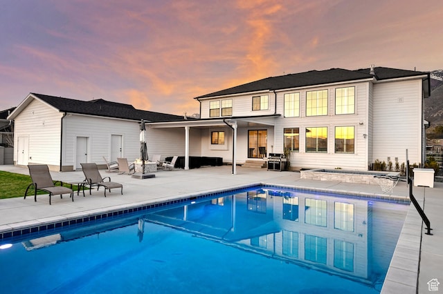back of house featuring a fire pit, an outdoor pool, and a patio