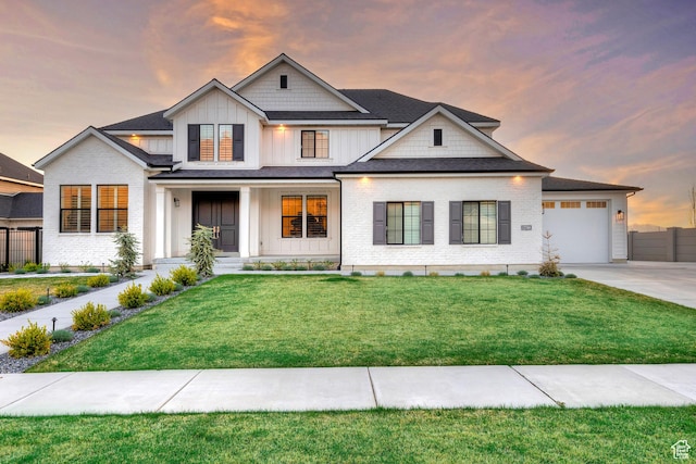 modern farmhouse style home with board and batten siding, an attached garage, a front lawn, and concrete driveway