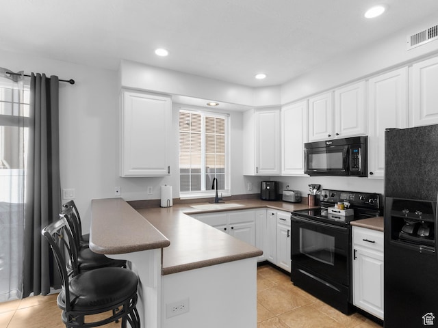 6939 S Tourist Ln W Unit 2C, West Jordan, UT 84084 - kitchen featuring a peninsula, a sink, visible vents, white cabinetry, and black appliances