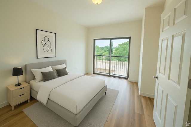 bedroom featuring light wood-style flooring, access to exterior, and baseboards