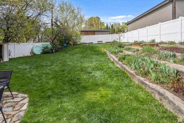 view of yard featuring a fenced backyard and a garden