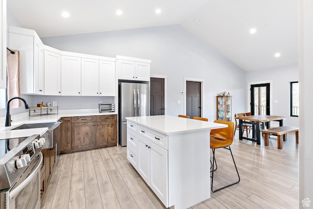 1678 S Ridgeline Dr Unit 1276, Heber City, UT 84032 - kitchen with high vaulted ceiling, appliances with stainless steel finishes, a kitchen bar, and light countertops