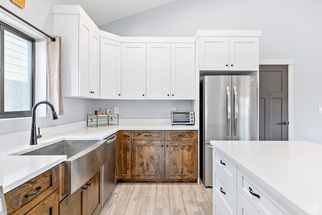 1678 S Ridgeline Dr Unit 1276, Heber City, UT 84032 - kitchen with vaulted ceiling, a sink, light wood-type flooring, appliances with stainless steel finishes, and white cabinetry