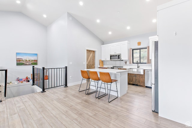 1678 S Ridgeline Dr Unit 1276, Heber City, UT 84032 - kitchen with white cabinets, a kitchen breakfast bar, stainless steel appliances, a sink, and a center island