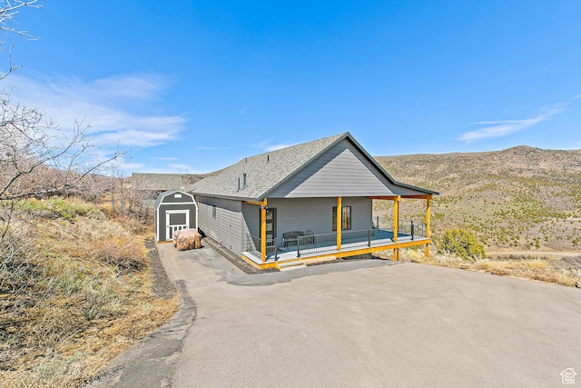 1678 S Ridgeline Dr Unit 1276, Heber City, UT 84032 - view of front of house with a storage shed, driveway, an outbuilding, a porch, and a mountain view