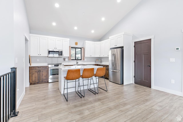 1678 S Ridgeline Dr Unit 1276, Heber City, UT 84032 - kitchen with white cabinets, stainless steel appliances, light countertops, a center island, and a breakfast bar area