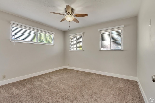 carpeted spare room with baseboards and ceiling fan