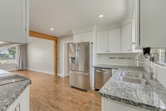 kitchen featuring plenty of natural light, a sink, appliances with stainless steel finishes, and tasteful backsplash