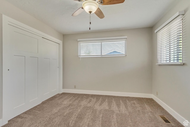 unfurnished bedroom featuring light colored carpet, baseboards, and visible vents