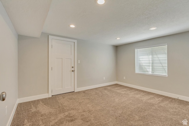 carpeted empty room with baseboards, recessed lighting, and a textured ceiling