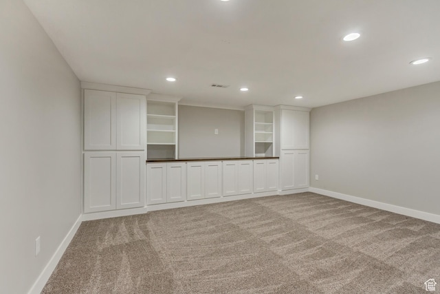 empty room featuring light colored carpet, baseboards, and recessed lighting