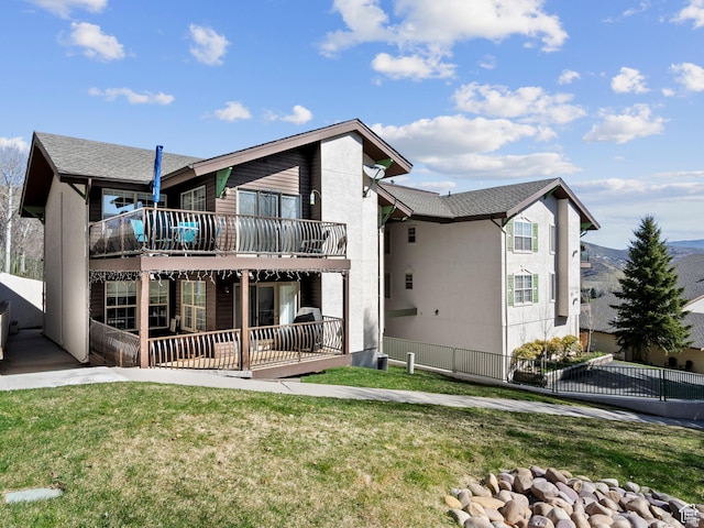 rear view of house with a patio area, a lawn, fence, and a deck