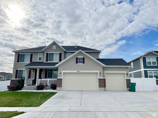3859 W Young Lucerne Cir, Riverton, UT 84065 - view of front of home featuring concrete driveway, brick siding, a garage, and covered porch