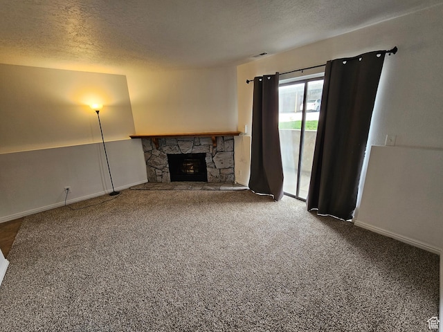 unfurnished living room featuring baseboards, carpet flooring, a textured ceiling, and a fireplace