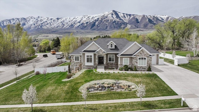 535 N Pheasant Hollow Ln, Mendon, UT 84325 - view of front of property featuring fence, a front lawn, concrete driveway, stone siding, and a mountain view