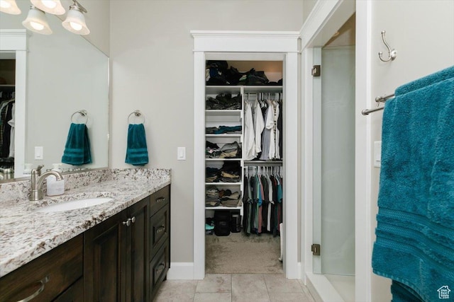 535 N Pheasant Hollow Ln, Mendon, UT 84325 - bathroom with a walk in closet, a shower stall, tile patterned floors, and vanity