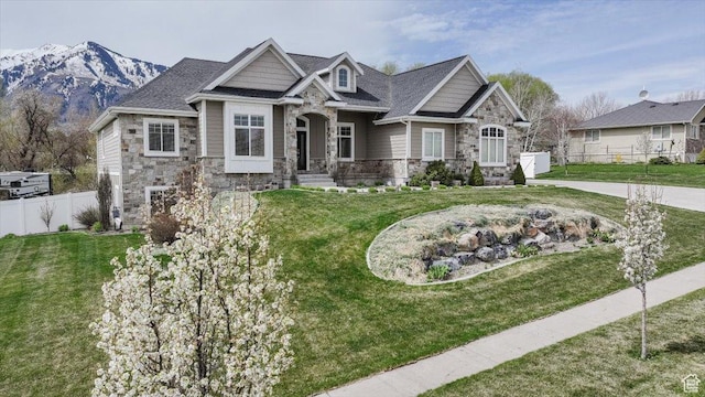 535 N Pheasant Hollow Ln, Mendon, UT 84325 - craftsman-style house featuring stone siding, a front lawn, fence, and a mountain view