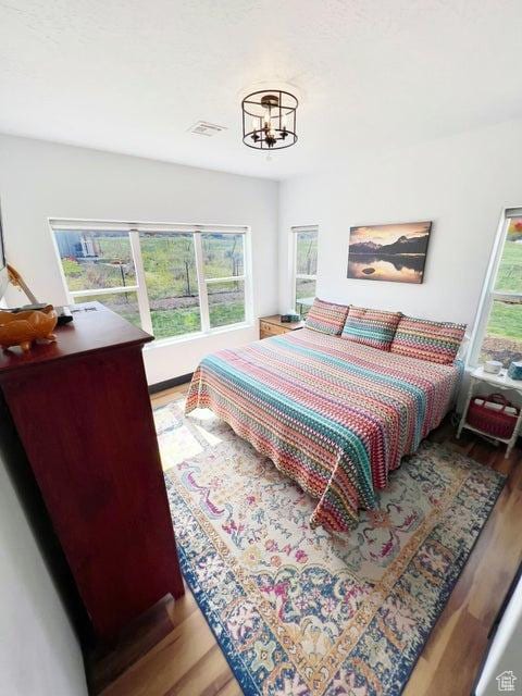 174 S 200 E, Pine Valley, UT 84781 - bedroom featuring an inviting chandelier, wood finished floors, and visible vents