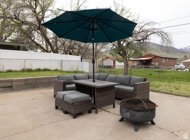view of patio / terrace featuring a fenced backyard, a fire pit, and a mountain view