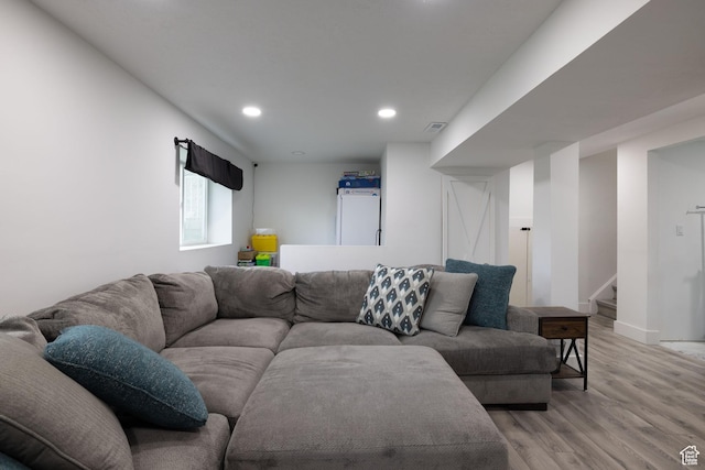 living area with light wood-type flooring, baseboards, visible vents, recessed lighting, and stairway