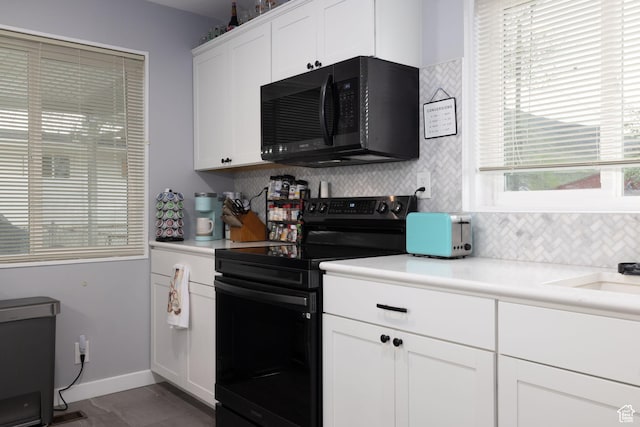 kitchen featuring light countertops, tasteful backsplash, a wealth of natural light, and black appliances
