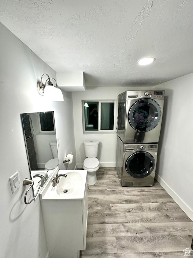 3436 S 8480 W, Magna, UT 84044 - bathroom featuring stacked washing machine and dryer, a textured ceiling, wood finished floors, and vanity