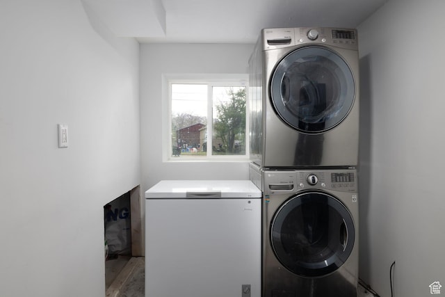 clothes washing area with stacked washer / dryer and laundry area