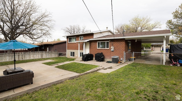 rear view of house featuring a gate, a fenced backyard, a yard, central air condition unit, and brick siding