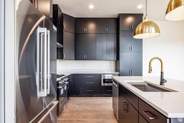 495 W Ascent Dr, Hideout, UT 84036 - kitchen with a sink, light wood-type flooring, decorative light fixtures, appliances with stainless steel finishes, and light stone countertops