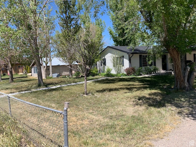 view of front facade featuring a front lawn and fence