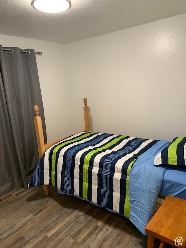 bedroom with wood finished floors and visible vents