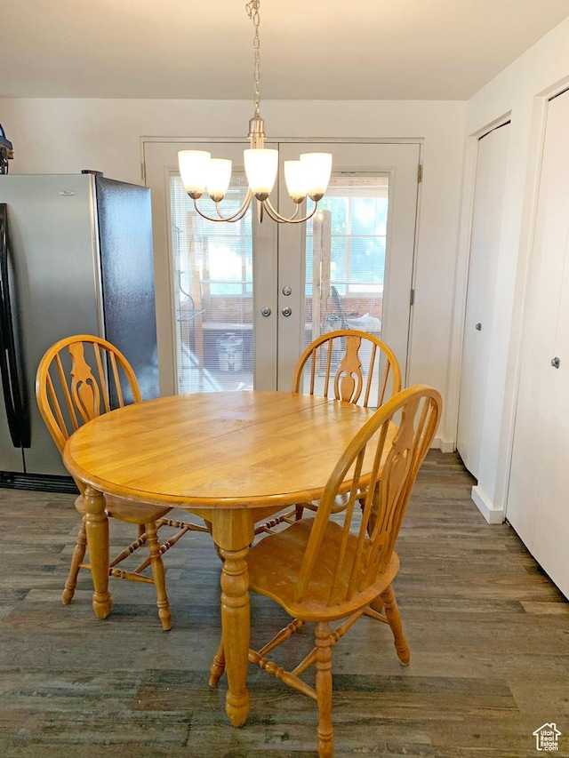 dining area featuring baseboards, a notable chandelier, and wood finished floors