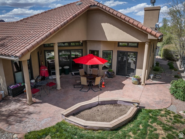 3270 E Rim Vistas Cir, Moab, UT 84532 - rear view of house with stucco siding, a tiled roof, and a patio