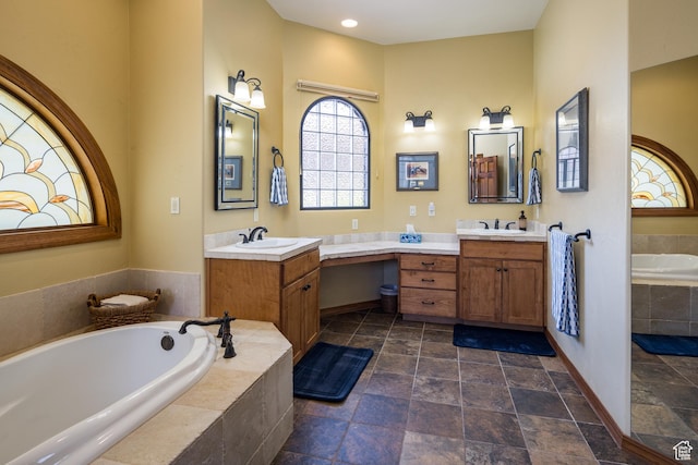 3270 E Rim Vistas Cir, Moab, UT 84532 - bathroom featuring stone tile floors, baseboards, a bath, and vanity
