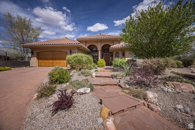 3270 E Rim Vistas Cir, Moab, UT 84532 - mediterranean / spanish home with a garage, driveway, a tiled roof, and stucco siding
