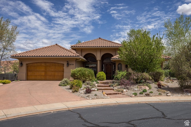 3270 E Rim Vistas Cir, Moab, UT 84532 - mediterranean / spanish house featuring a garage, stucco siding, a tile roof, and concrete driveway