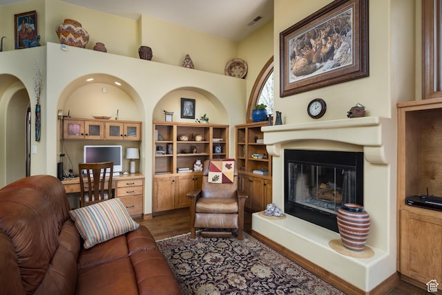 3270 E Rim Vistas Cir, Moab, UT 84532 - living area with visible vents, a glass covered fireplace, and dark wood-type flooring