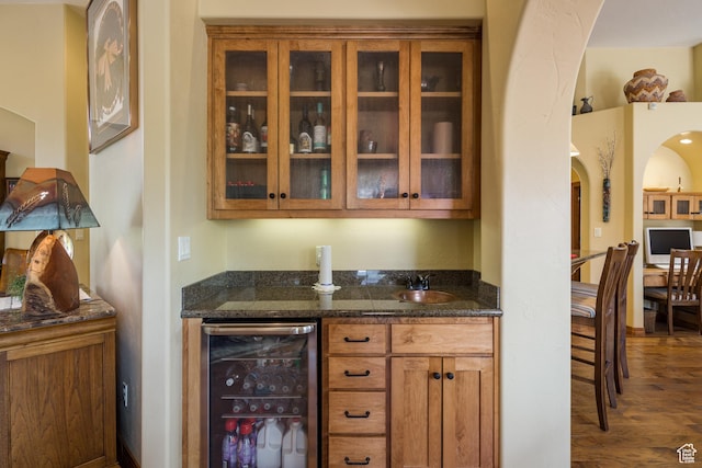 3270 E Rim Vistas Cir, Moab, UT 84532 - bar with arched walkways, beverage cooler, and wood finished floors