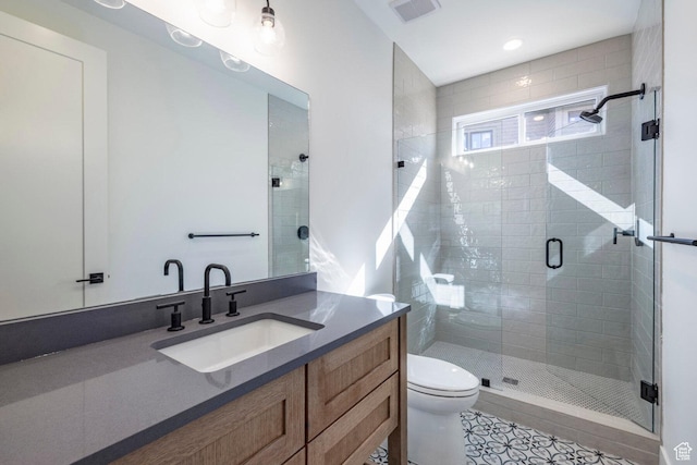 full bath with tile patterned floors, toilet, visible vents, a shower stall, and vanity