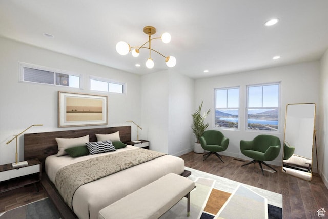 bedroom with baseboards, wood finished floors, an inviting chandelier, and recessed lighting