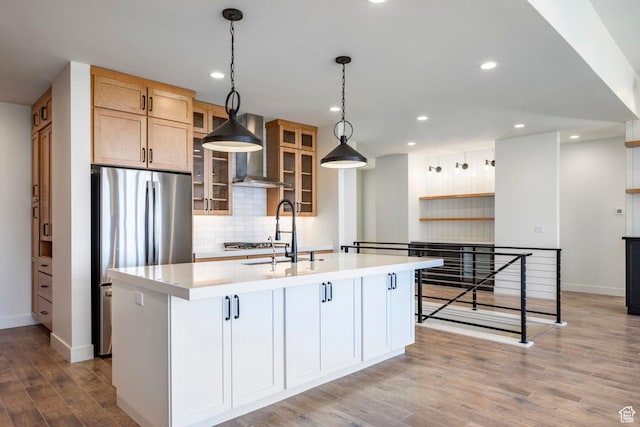 kitchen featuring tasteful backsplash, a sink, light countertops, and freestanding refrigerator