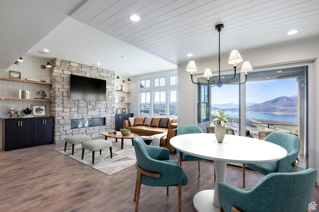 dining room featuring a chandelier, wood finished floors, a fireplace, and recessed lighting