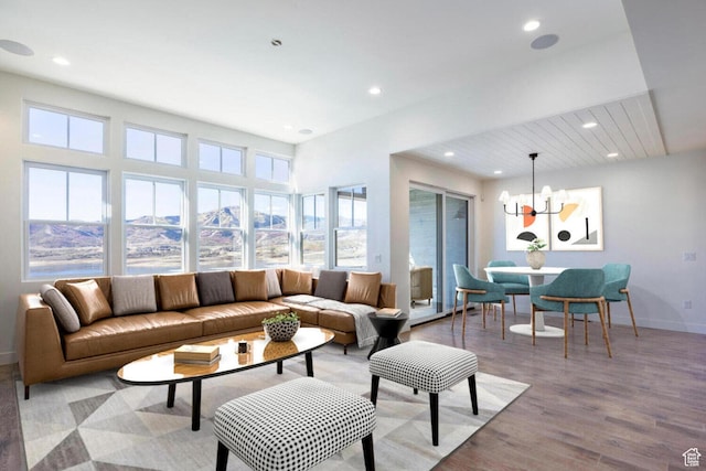 living room featuring an inviting chandelier, light wood-style flooring, baseboards, and recessed lighting