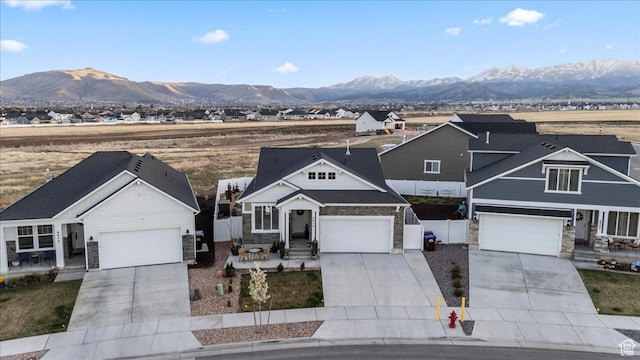 6079 W Teton Village Dr Unit 106, Herriman, UT 84096 - view of front of house with concrete driveway, a mountain view, fence, and stone siding
